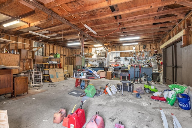 miscellaneous room with a garage, concrete flooring, and a workshop area