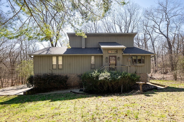 view of front of house featuring a front lawn, roof with shingles, and brick siding