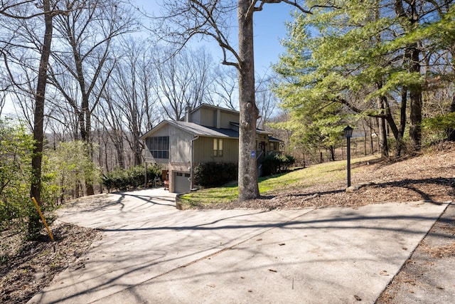 view of side of property with a garage and concrete driveway