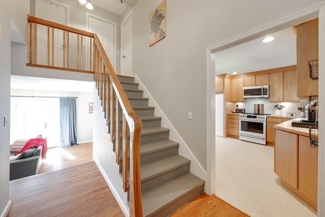 stairs with baseboards and recessed lighting