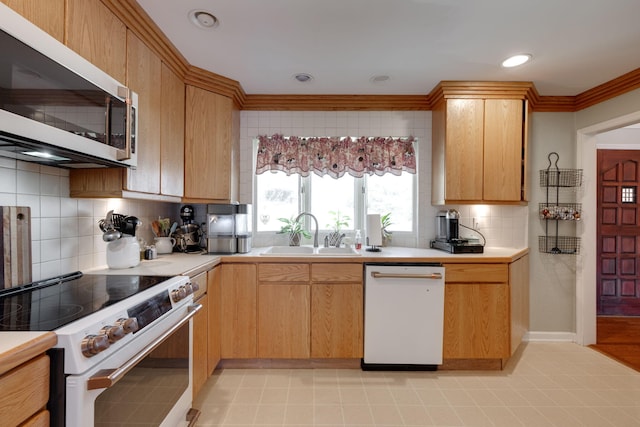 kitchen featuring white appliances, a sink, light countertops, ornamental molding, and decorative backsplash