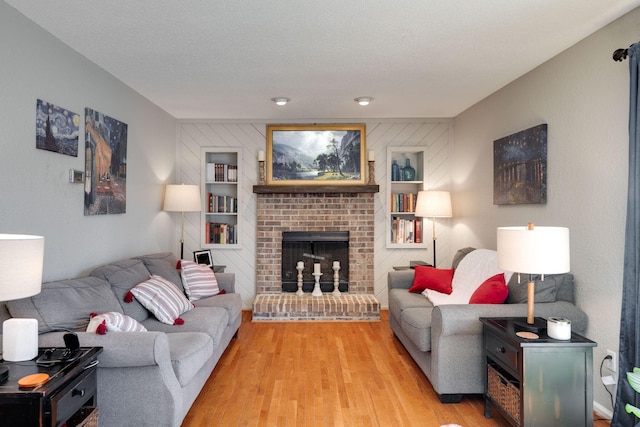 living room with a brick fireplace and light wood-style flooring