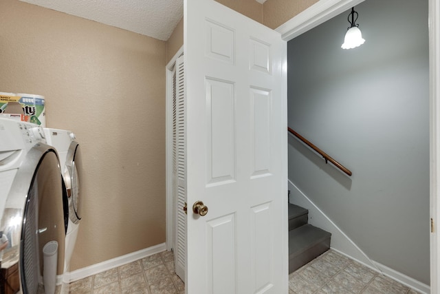 clothes washing area featuring laundry area, washing machine and dryer, and baseboards