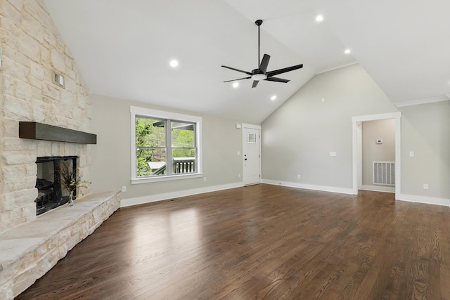 unfurnished living room with dark wood-type flooring, a ceiling fan, a stone fireplace, visible vents, and lofted ceiling
