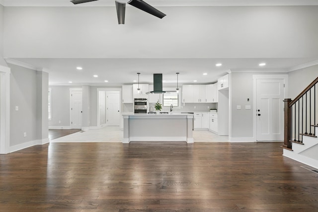 unfurnished living room featuring recessed lighting, wood finished floors, stairs, ceiling fan, and visible vents