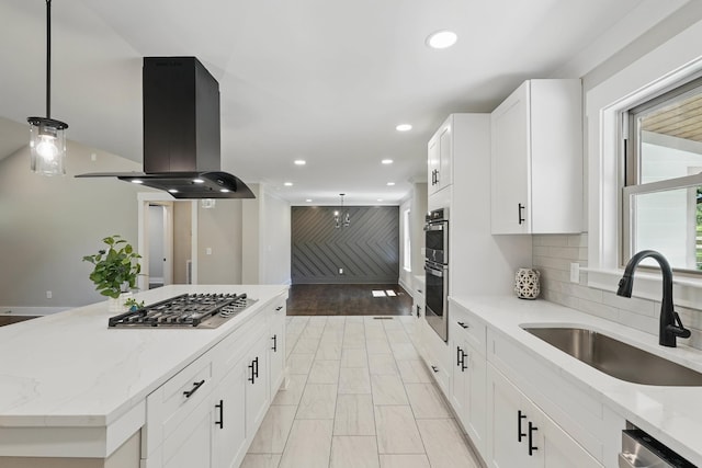 kitchen featuring recessed lighting, a sink, island exhaust hood, pendant lighting, and appliances with stainless steel finishes