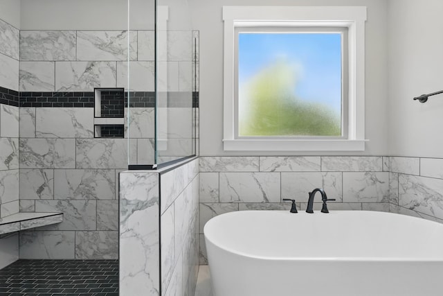 bathroom featuring a walk in shower, a healthy amount of sunlight, and a soaking tub