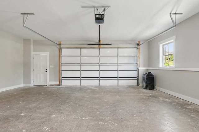 garage featuring a garage door opener and baseboards