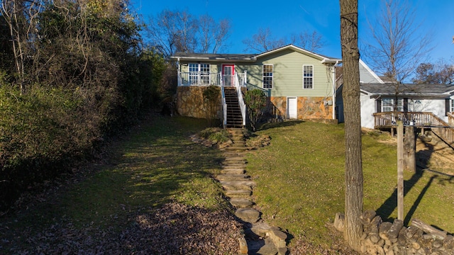 exterior space with stone siding, stairway, and a front lawn