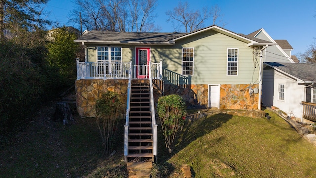 view of front facade featuring stone siding, stairway, and a front lawn