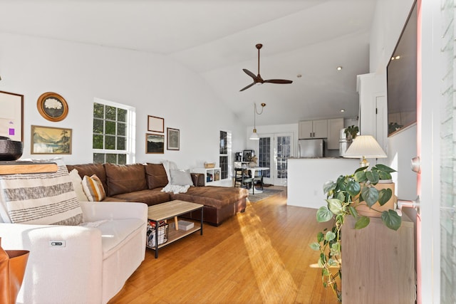 living room with high vaulted ceiling, light wood-type flooring, and a ceiling fan