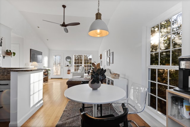 dining area featuring lofted ceiling, light wood-style floors, and a ceiling fan