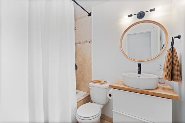 bathroom with tiled shower, vanity, and toilet