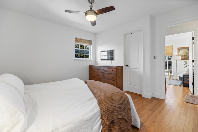 bedroom with ceiling fan, light wood-type flooring, and baseboards