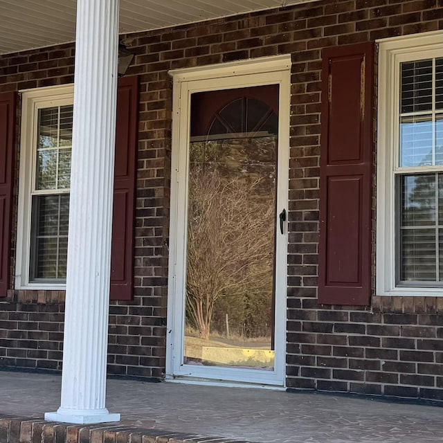 doorway to property with brick siding