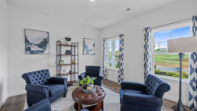 sitting room with visible vents, a wealth of natural light, and wood finished floors