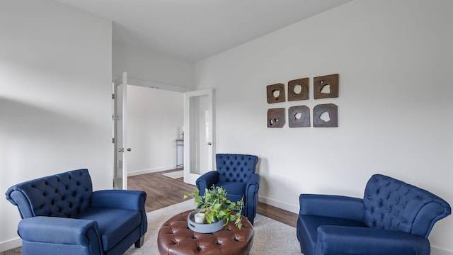 living area featuring baseboards and wood finished floors