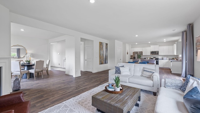 living area with baseboards, light wood-type flooring, and recessed lighting