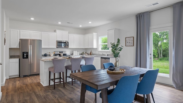 dining area with dark wood-style flooring, visible vents, and recessed lighting