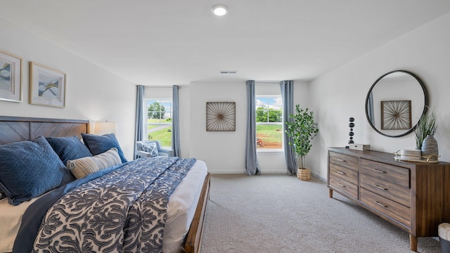 bedroom featuring light colored carpet, visible vents, and baseboards