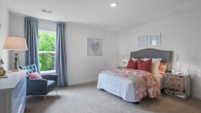 bedroom with visible vents, light carpet, and baseboards