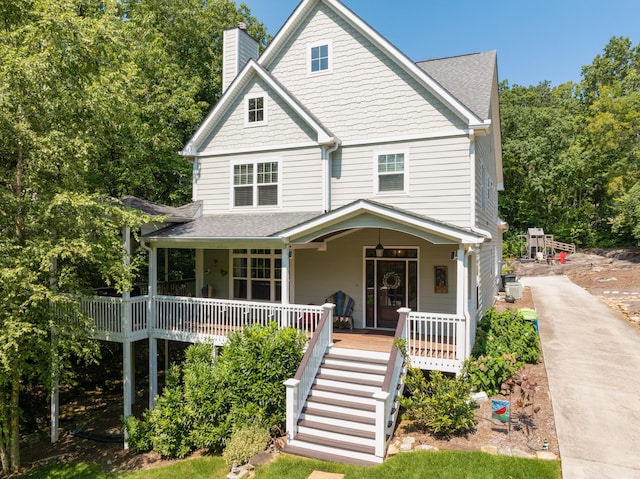 view of front of home featuring a porch, roof with shingles, and a chimney