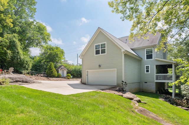 view of side of property featuring a lawn, driveway, and an attached garage