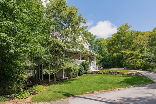 view of front of house with covered porch and a front lawn