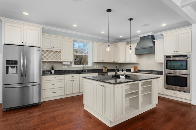 kitchen featuring dark wood-style flooring, custom exhaust hood, open shelves, stainless steel appliances, and an island with sink