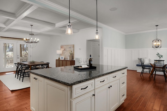 kitchen with coffered ceiling, beam ceiling, a center island, dark wood-style floors, and an inviting chandelier