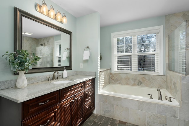 bathroom featuring a garden tub, a tile shower, and vanity