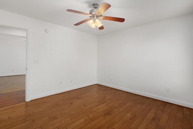 spare room featuring hardwood / wood-style flooring, baseboards, and a ceiling fan