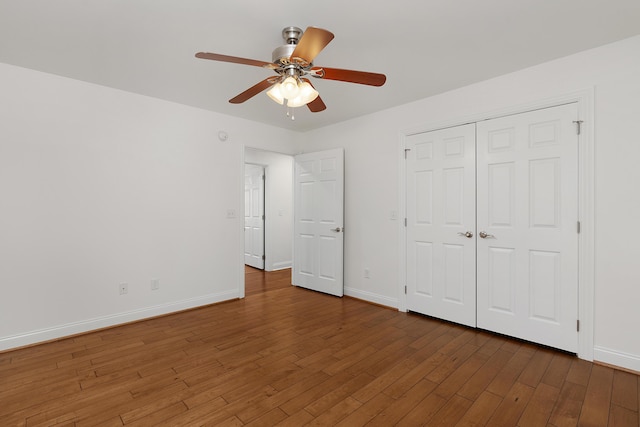 unfurnished bedroom with ceiling fan, a closet, wood finished floors, and baseboards