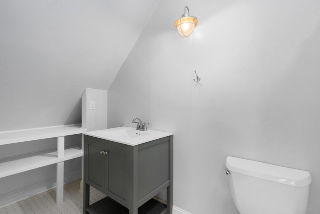 half bath featuring toilet, vaulted ceiling, and vanity