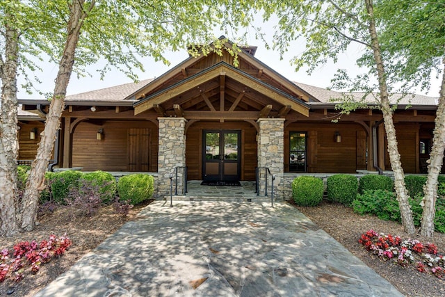 property entrance with stone siding and a porch