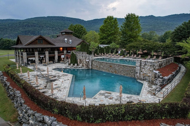 pool featuring a mountain view, fence, and a patio