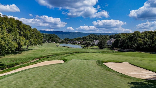 surrounding community featuring a water view, a lawn, and golf course view