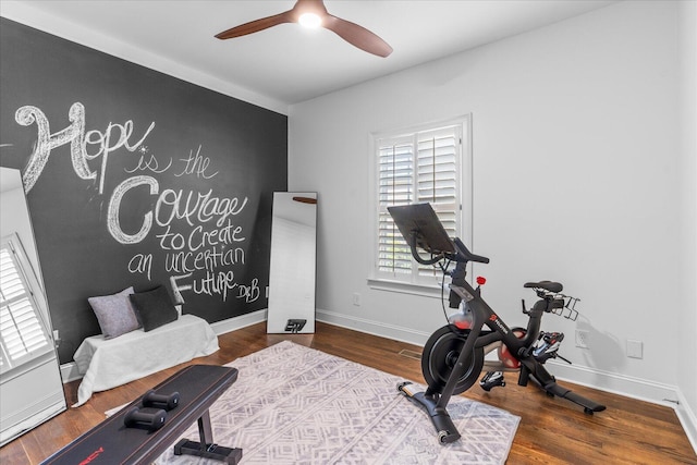 workout room with ceiling fan, dark wood-style flooring, and baseboards