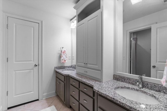 full bathroom featuring double vanity, tile patterned flooring, and a sink