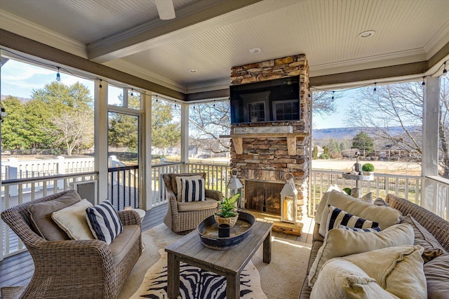 sunroom / solarium featuring plenty of natural light and an outdoor stone fireplace