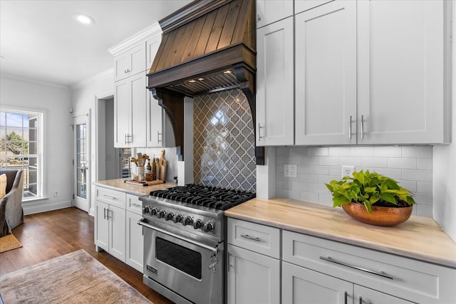 kitchen with white cabinets, designer stove, light countertops, crown molding, and premium range hood