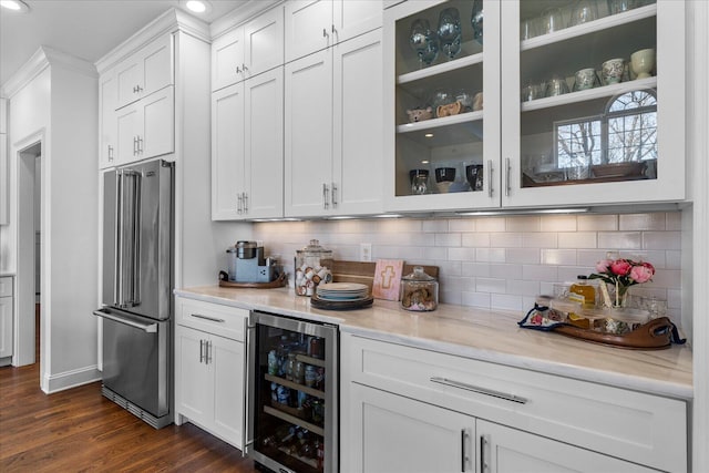 bar featuring dark wood finished floors, high end fridge, recessed lighting, backsplash, and beverage cooler