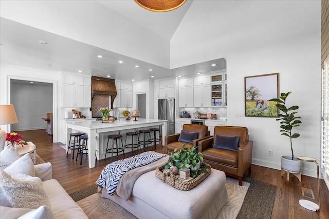 living room featuring dark wood-style floors, a high ceiling, visible vents, and baseboards