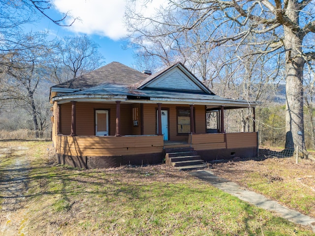 bungalow-style house featuring covered porch, roof with shingles, and crawl space