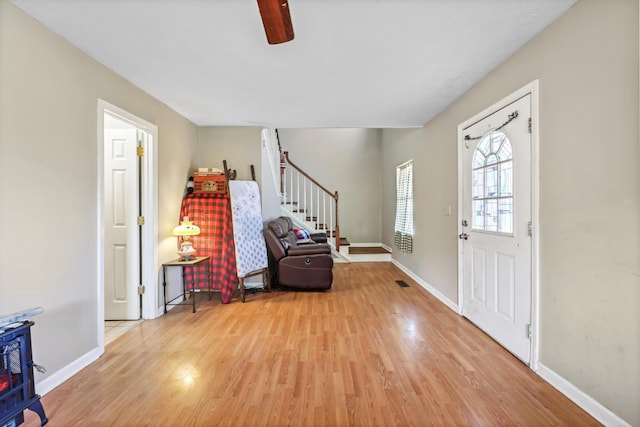 foyer featuring stairway, light wood-style flooring, and baseboards