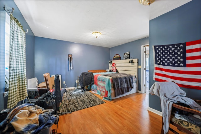 bedroom with baseboards and wood finished floors