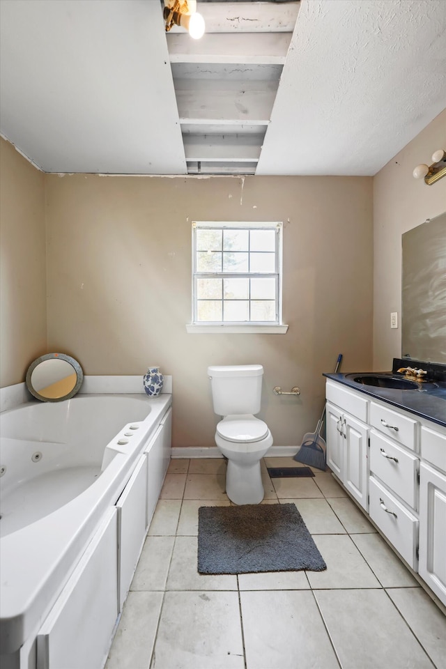 bathroom featuring toilet, vanity, baseboards, tile patterned floors, and a whirlpool tub