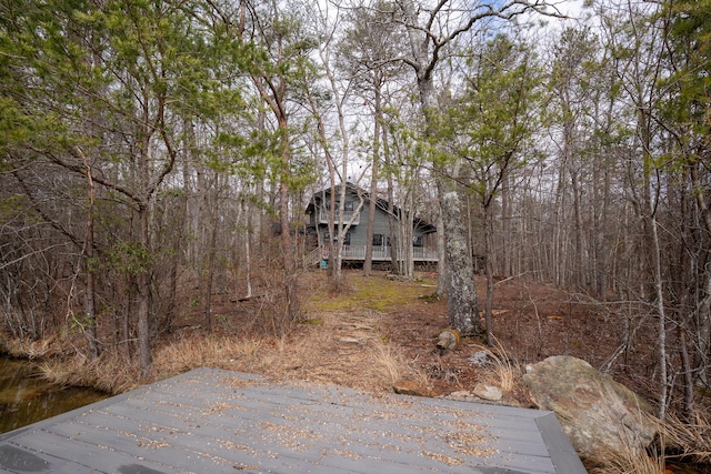 view of yard featuring a deck and a view of trees