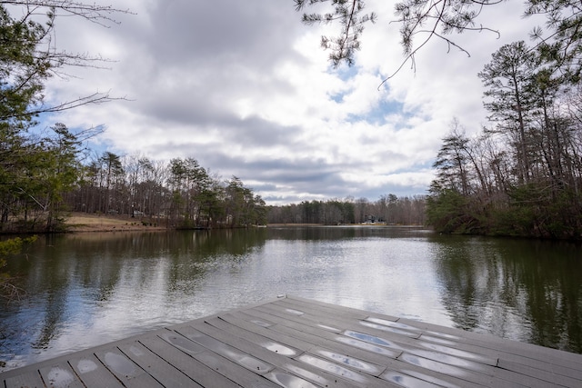 view of dock featuring a water view and a wooded view