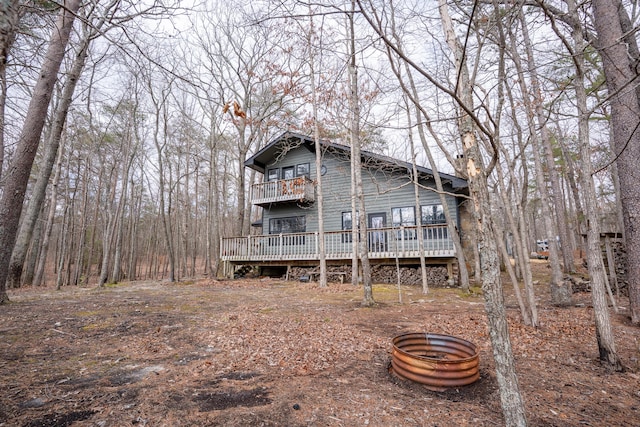 rear view of house featuring a chimney and a balcony